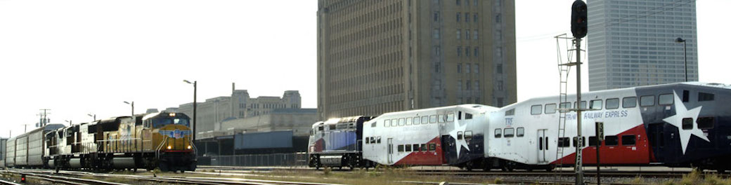 passenger train with Texas flag paint alongside freight train